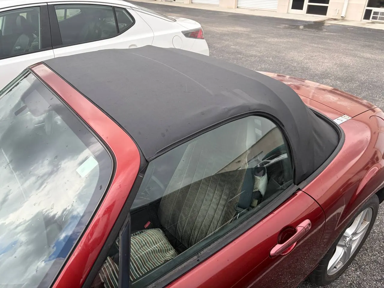 Worn convertible top on a red roadster before replacement in North Port, FL