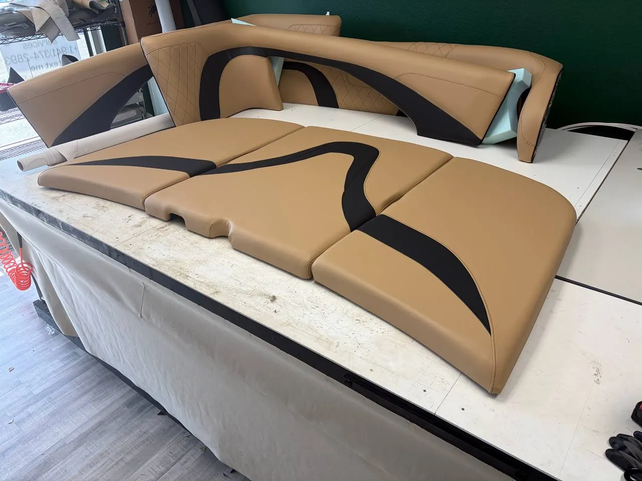 Camel and black pontoon boat cushions being rebuilt on the workbench in North Port, FL