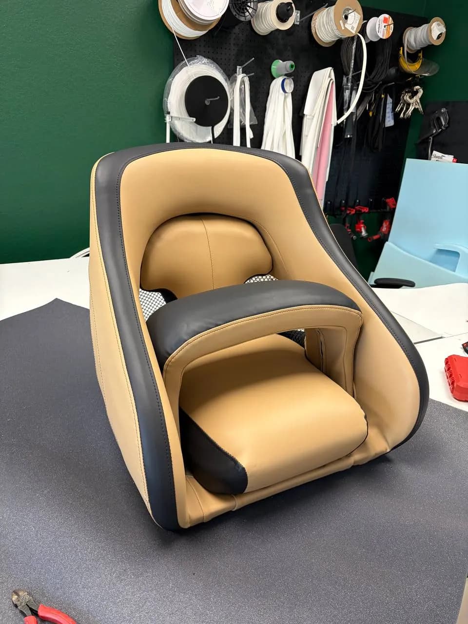 Rebuilt camel and black bucket helm seat for a pontoon boat